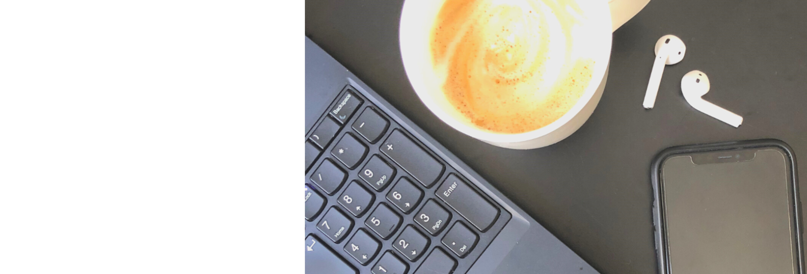 Et arbejdsbord med computer, mobil og kaffe